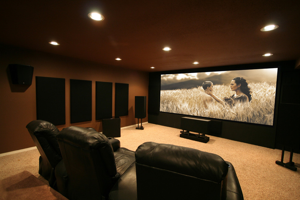 Photo of a large traditional home theatre in Seattle with a projector screen, multi-coloured walls, carpet and beige floor.