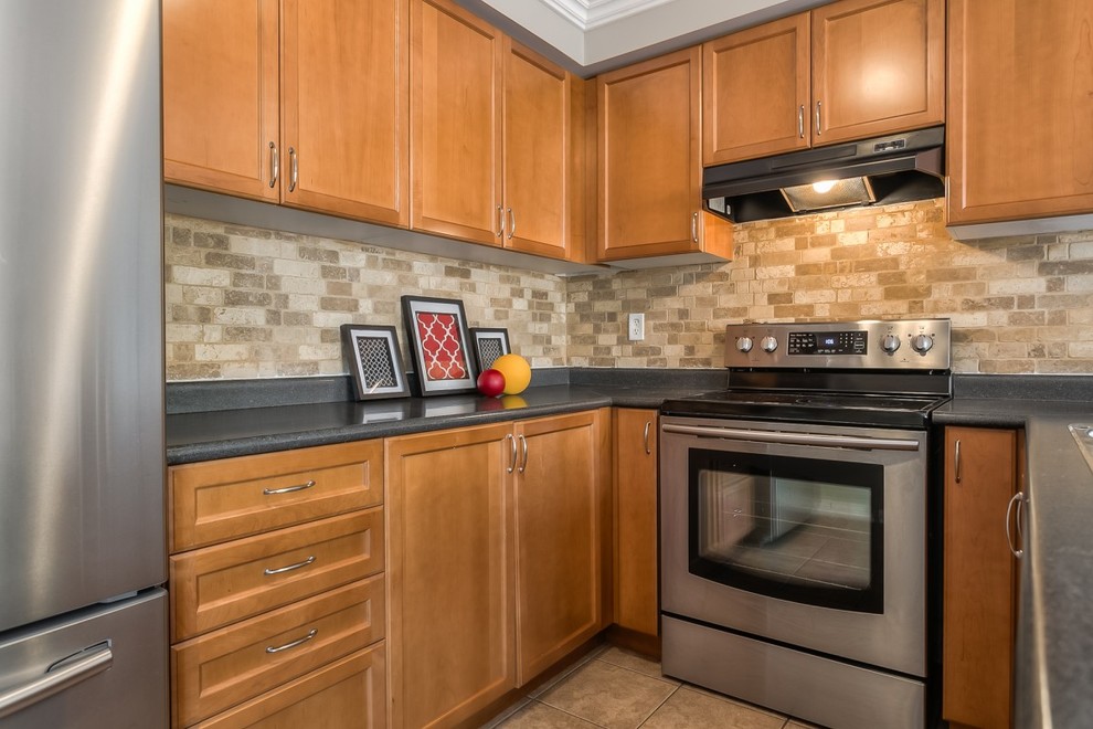 Inspiration for a mid-sized transitional u-shaped ceramic tile eat-in kitchen remodel in Toronto with a double-bowl sink, beaded inset cabinets, medium tone wood cabinets, laminate countertops, brown backsplash, stainless steel appliances and an island