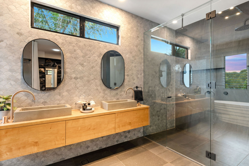 Contemporary bathroom in Sunshine Coast with flat-panel cabinets, medium wood cabinets, gray tile, a vessel sink, wood benchtops, grey floor, brown benchtops and a double vanity.
