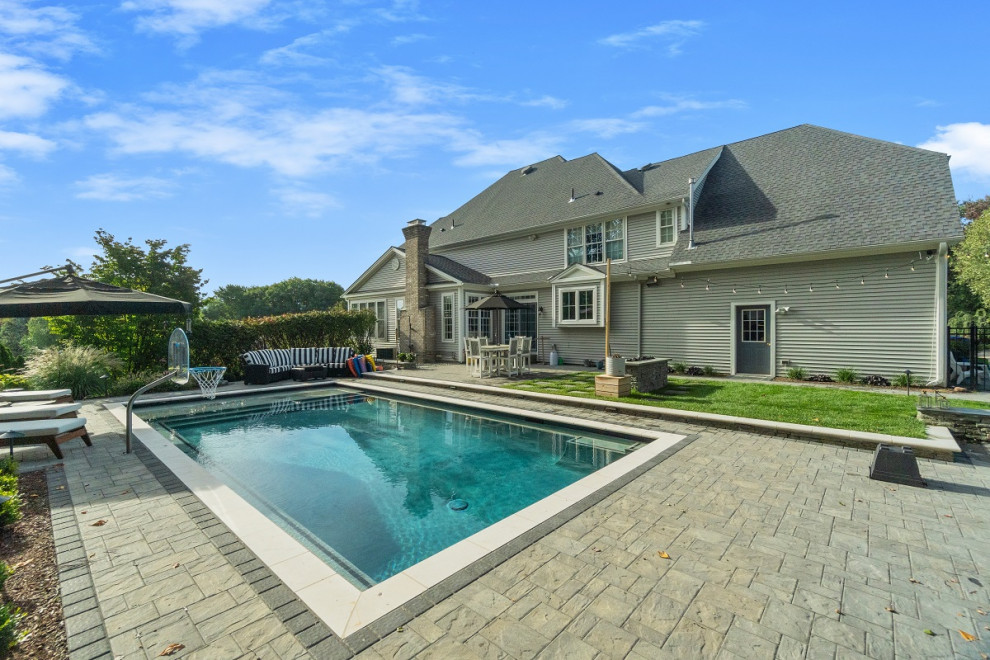 Источник вдохновения для домашнего уюта: большой прямоугольный ландшафтный бассейн на заднем дворе в классическом стиле с покрытием из каменной брусчатки
