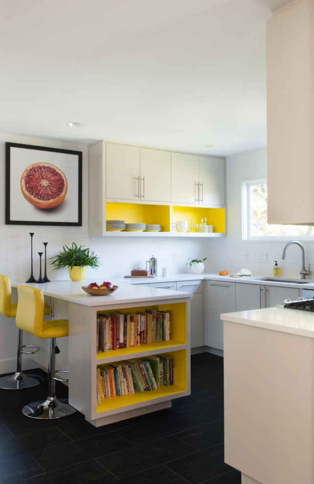 Inspiration for a small modern u-shaped eat-in kitchen in Austin with an undermount sink, open cabinets, yellow cabinets, quartzite benchtops, white splashback, ceramic splashback, stainless steel appliances, cement tiles, a peninsula, black floor and white benchtop.