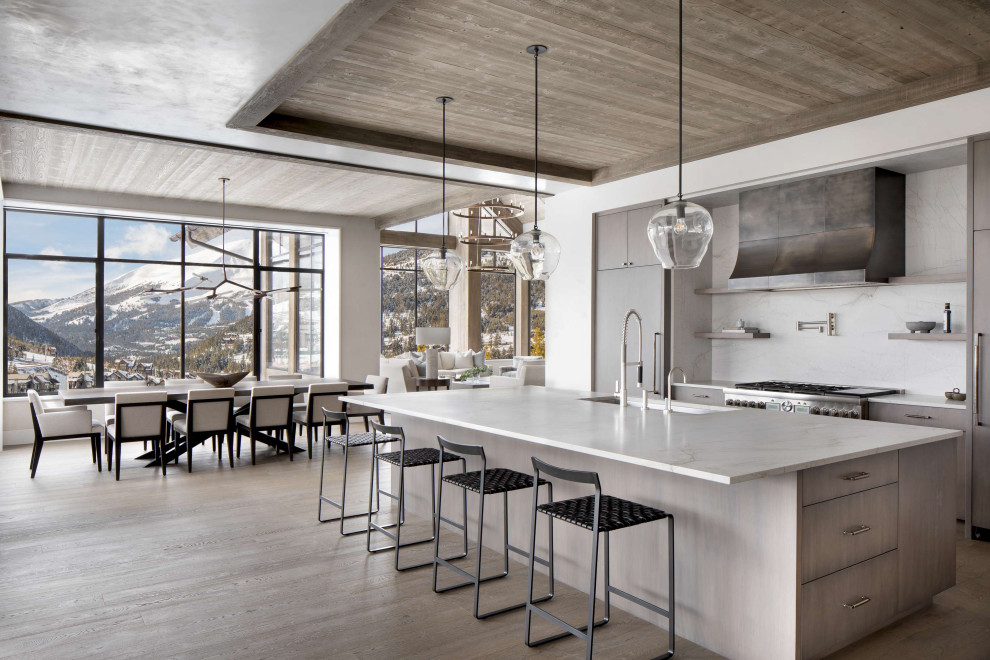 Mountain style medium tone wood floor and wood ceiling eat-in kitchen photo with an undermount sink, flat-panel cabinets, white backsplash, an island and white countertops