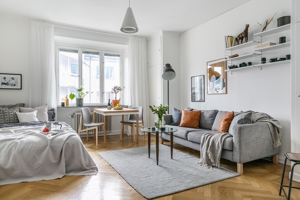 Photo of a small scandinavian formal open concept living room in Stockholm with white walls, medium hardwood floors and beige floor.