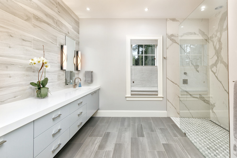 This is an example of a transitional bathroom in Charleston with flat-panel cabinets, grey cabinets, a curbless shower, gray tile, grey walls, an undermount sink, grey floor, an open shower and white benchtops.