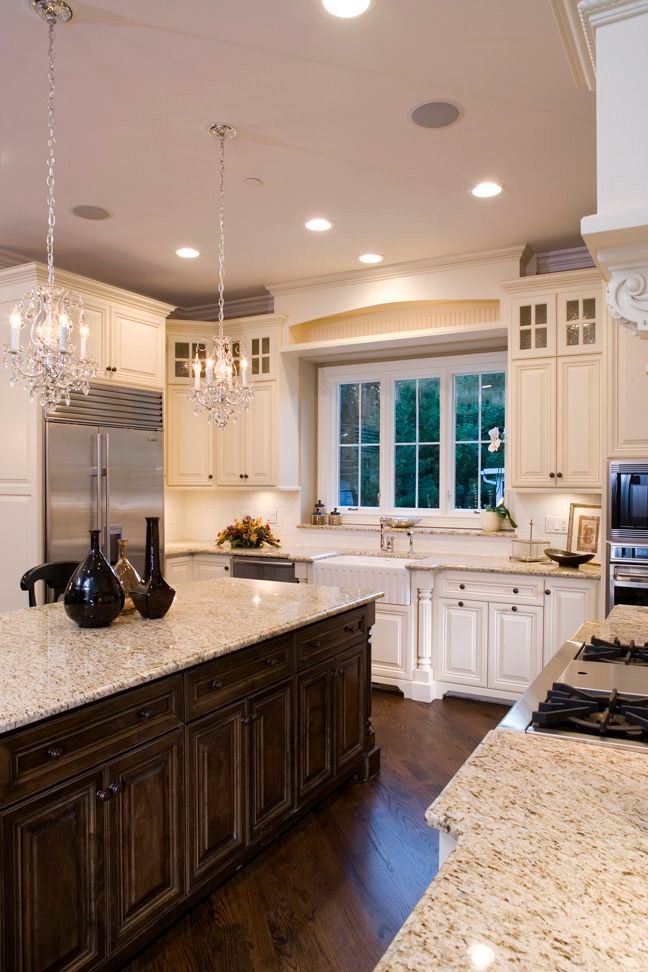 Inspiration for a large transitional u-shaped dark wood floor eat-in kitchen remodel in Toronto with a farmhouse sink, raised-panel cabinets, white cabinets, granite countertops, white backsplash, stainless steel appliances and an island