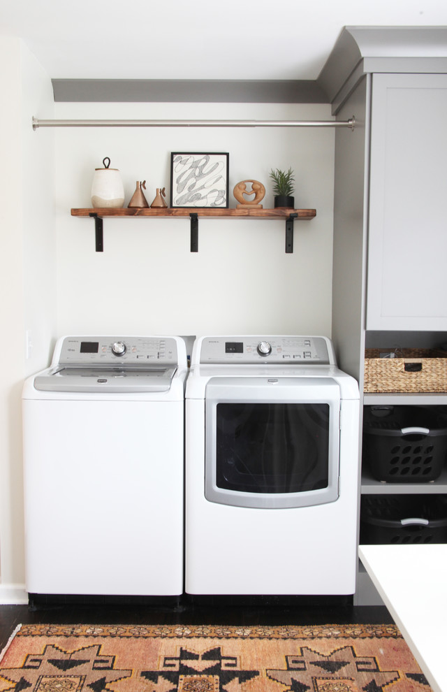 Design ideas for a small transitional laundry room in Chicago with grey cabinets, wood benchtops, dark hardwood floors, a side-by-side washer and dryer and brown floor.