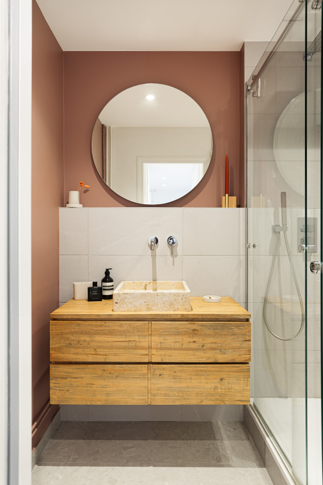 Idéer för ett litet modernt en-suite badrum, med skåp i ljust trä, en öppen dusch, en toalettstol med separat cisternkåpa, grå kakel, stenhäll, rosa väggar, ett fristående handfat, träbänkskiva, grått golv och dusch med skjutdörr
