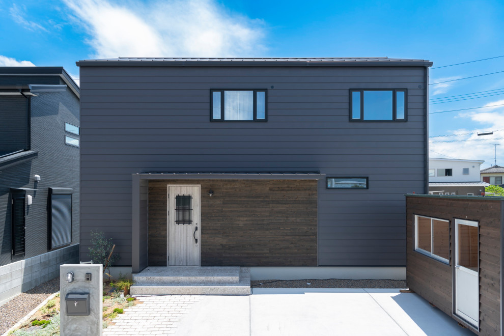 This is an example of a modern two-storey black house exterior in Other with a black roof.