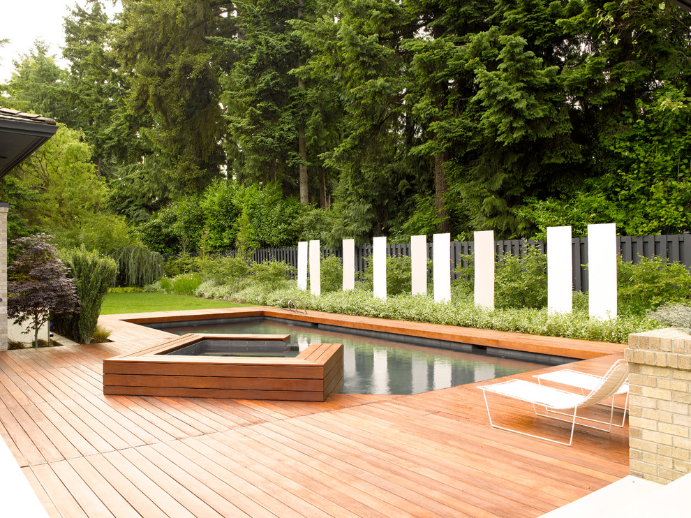 This is an example of a mid-sized contemporary rectangular pool in Seattle with decking.