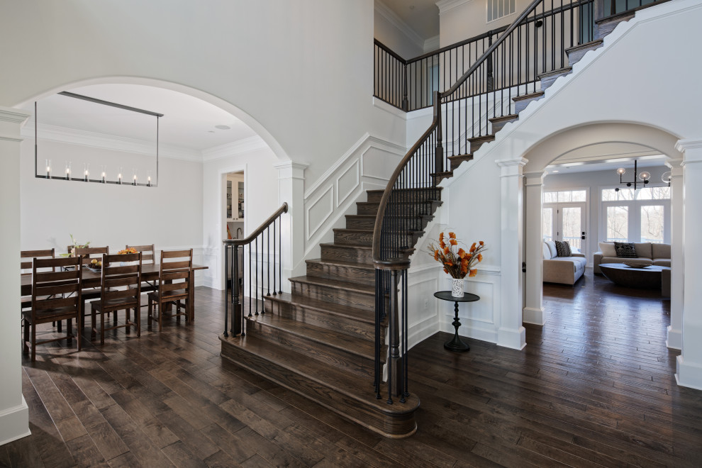 Mid-sized traditional wood l-shaped staircase in DC Metro with wood railing, decorative wall panelling and wood risers.
