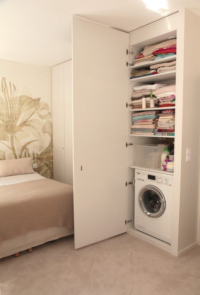 Photo of a small contemporary single-wall laundry cupboard in Other with beaded inset cabinets and white cabinets.