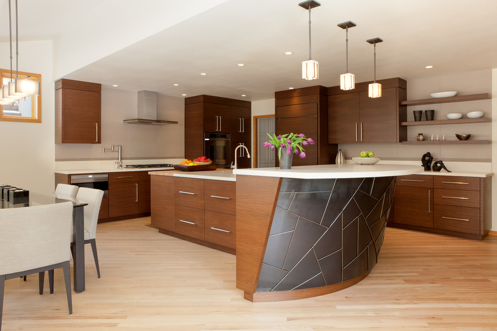 This is an example of a mid-sized contemporary l-shaped eat-in kitchen in Portland with flat-panel cabinets, dark wood cabinets, panelled appliances, an undermount sink, concrete benchtops, grey splashback, porcelain splashback, light hardwood floors, with island and beige floor.