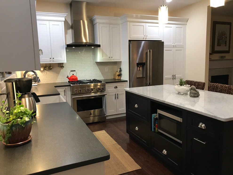 Inspiration for a mid-sized transitional l-shaped laminate floor and brown floor eat-in kitchen remodel with a farmhouse sink, beaded inset cabinets, white cabinets, quartz countertops, white backsplash, subway tile backsplash, stainless steel appliances and an island