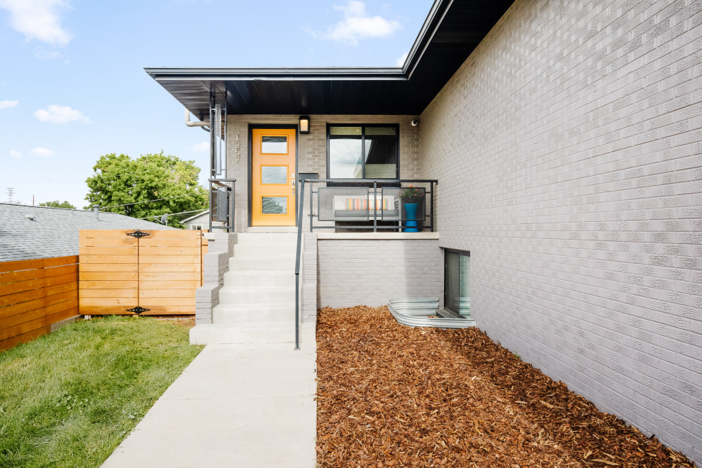Idéer för funkis verandor framför huset, med betongplatta, takförlängning och räcke i metall