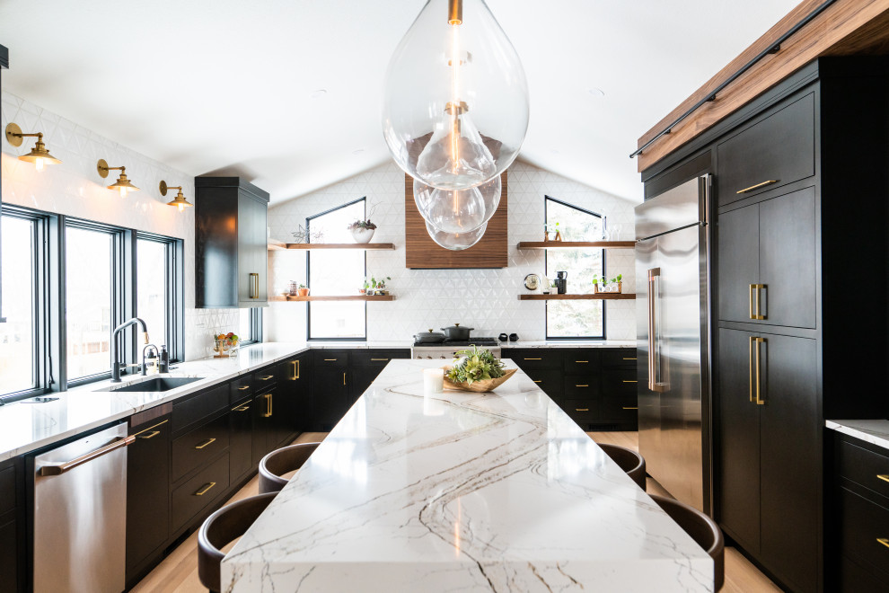 Photo of a midcentury kitchen in Other with an undermount sink, flat-panel cabinets, black cabinets, quartz benchtops, white splashback, ceramic splashback, stainless steel appliances, light hardwood floors, with island, multi-coloured benchtop and vaulted.