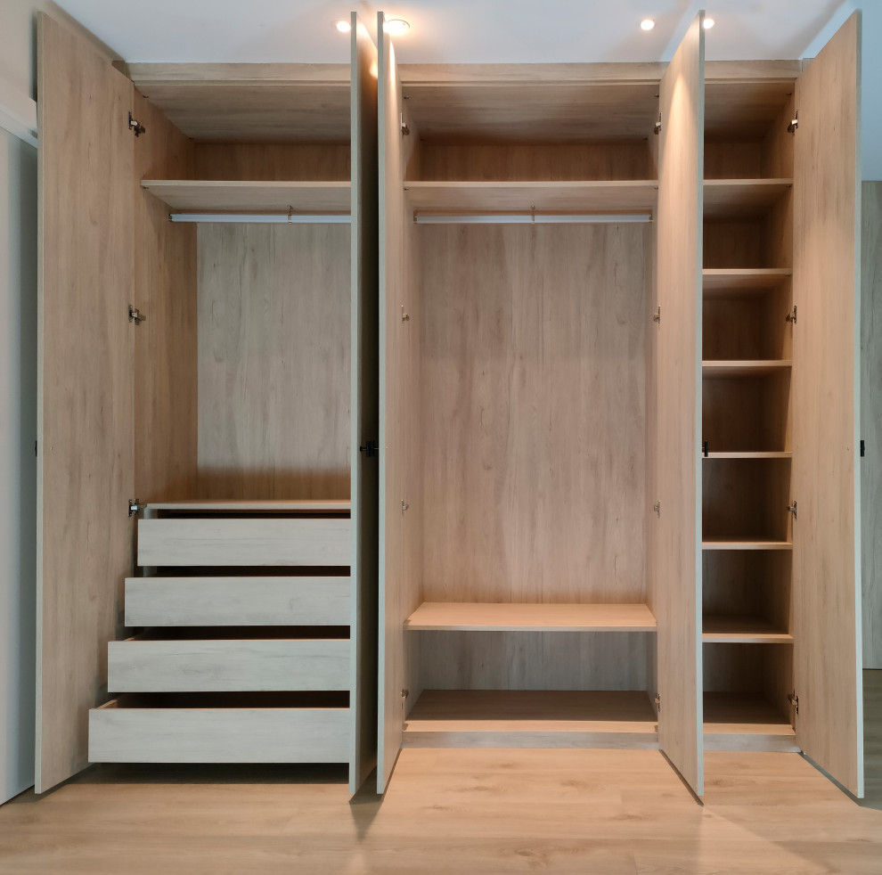 Foto de armario y vestidor moderno grande con a medida, armarios con paneles empotrados, puertas de armario de madera clara y suelo de madera clara