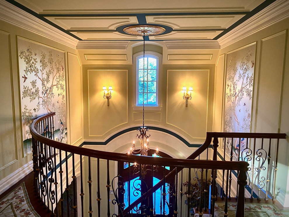 This is an example of a large traditional foyer in New York with green walls, marble floors, a double front door, a brown front door, white floor, coffered and panelled walls.
