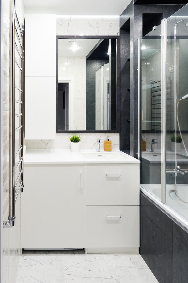 This is an example of a mid-sized contemporary master bathroom in Other with flat-panel cabinets, white cabinets, an alcove tub, white tile, porcelain tile, porcelain floors, an undermount sink, solid surface benchtops, white floor and white benchtops.