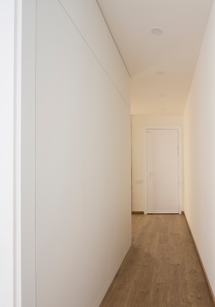 Inspiration for a mid-sized modern hallway with white walls and medium hardwood floors.