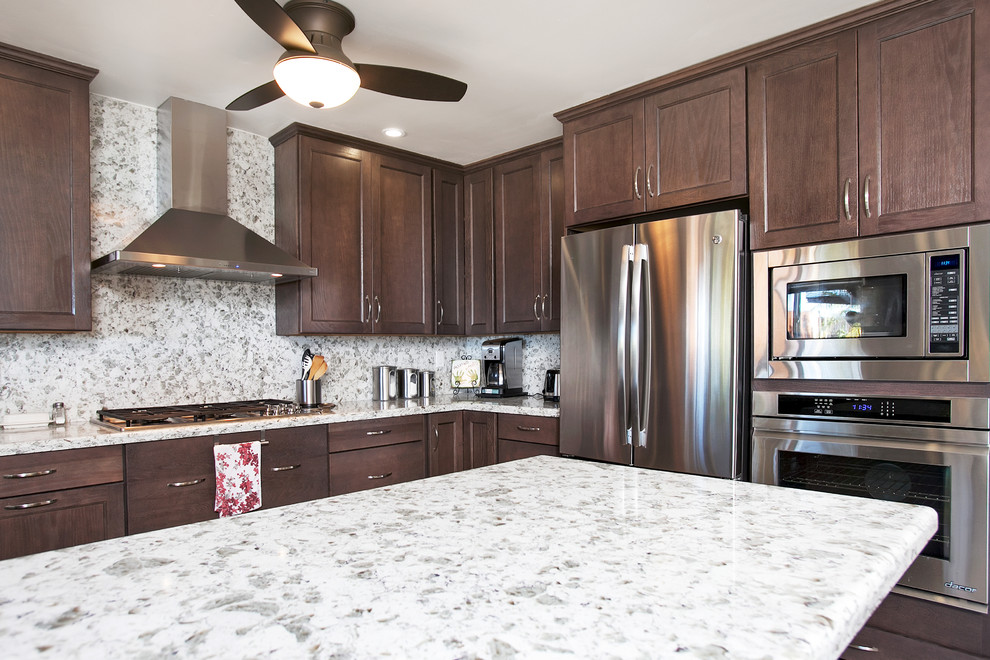 Eat-in kitchen - large transitional u-shaped porcelain tile eat-in kitchen idea in San Diego with an undermount sink, recessed-panel cabinets, dark wood cabinets, quartz countertops, white backsplash, stone slab backsplash, stainless steel appliances and a peninsula