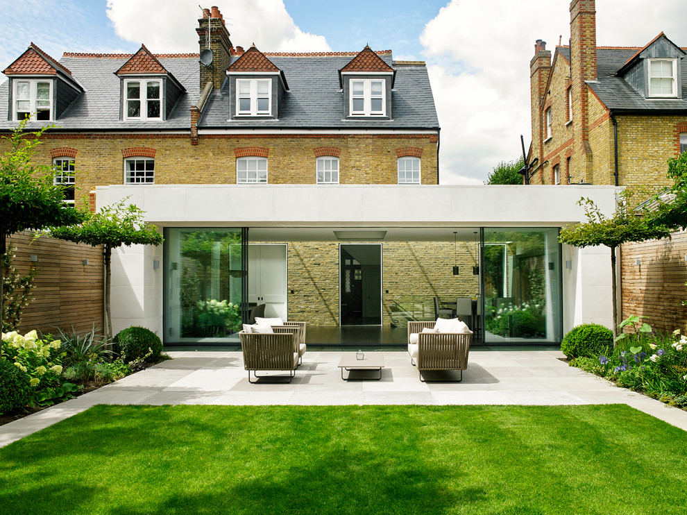 Inspiration for a mid-sized contemporary backyard patio in London with no cover and concrete pavers.