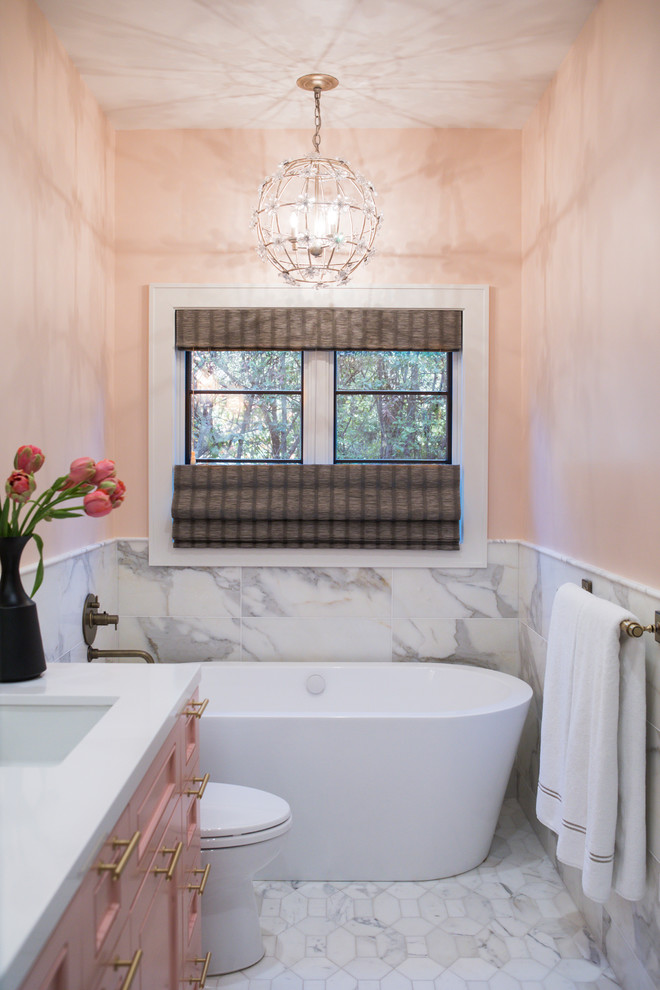 Design ideas for a mid-sized eclectic master bathroom in San Francisco with shaker cabinets, a freestanding tub, an alcove shower, a one-piece toilet, pink tile, marble, marble floors, an undermount sink, white floor, a hinged shower door and white benchtops.