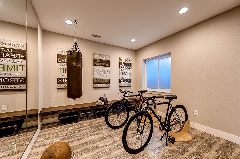 This is an example of a large transitional multipurpose gym in Denver with beige walls, laminate floors and brown floor.