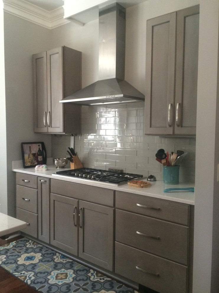 Open concept kitchen - mid-sized transitional single-wall dark wood floor open concept kitchen idea with shaker cabinets, dark wood cabinets, marble countertops, gray backsplash, glass tile backsplash, stainless steel appliances and an island