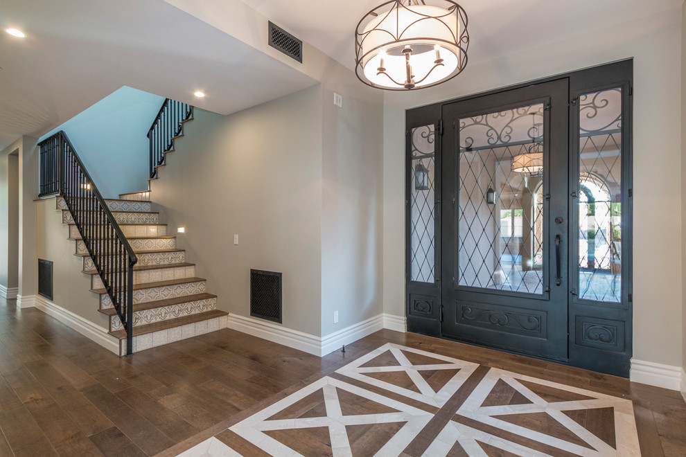 Inspiration for a huge transitional medium tone wood floor and brown floor foyer remodel in Phoenix with gray walls and a metal front door