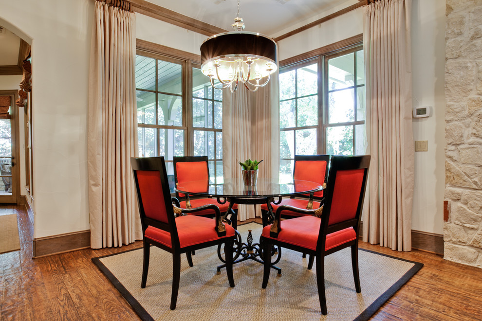 This is an example of a traditional dining room in Dallas with white walls and dark hardwood floors.