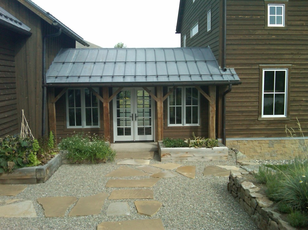 Design ideas for an expansive country courtyard patio in Boise with a vegetable garden, gravel and a roof extension.