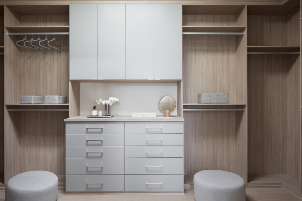Inspiration for a large modern walk-in wardrobe in San Francisco with flat-panel cabinets, light wood cabinets and light hardwood floors.