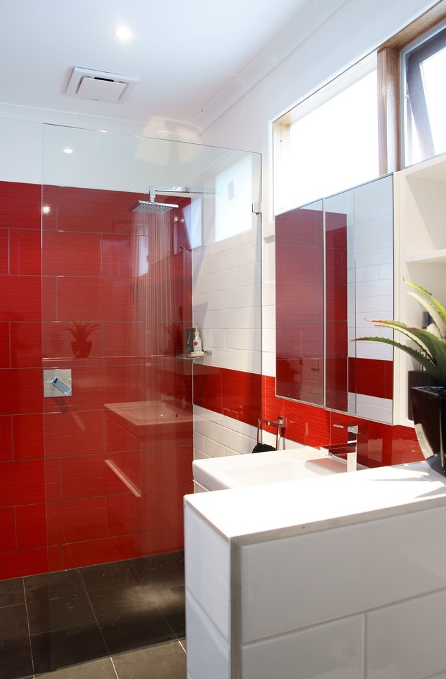 Mid-sized contemporary master bathroom in Melbourne with furniture-like cabinets, white cabinets, an open shower, a two-piece toilet, red tile, ceramic tile, white walls, ceramic floors, an integrated sink and solid surface benchtops.