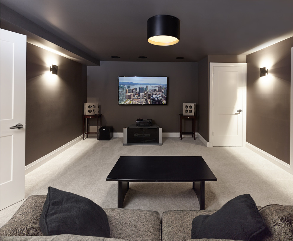 Photo of a mid-sized transitional enclosed home theatre in Vancouver with brown walls, carpet, a wall-mounted tv and beige floor.
