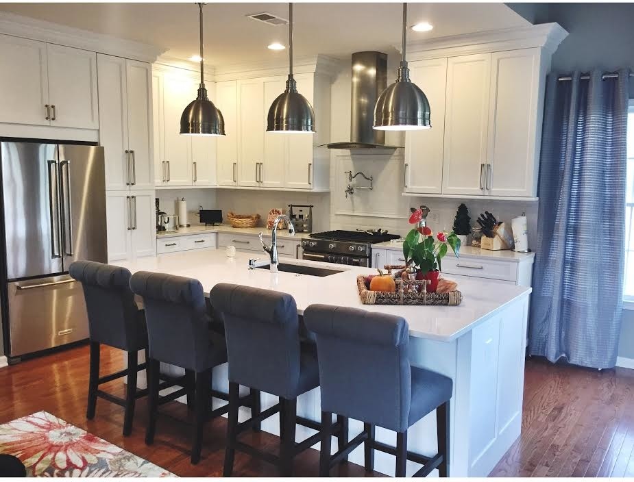 Large transitional l-shaped light wood floor eat-in kitchen photo in DC Metro with an undermount sink, shaker cabinets, white cabinets, quartz countertops, white backsplash, subway tile backsplash, stainless steel appliances and an island