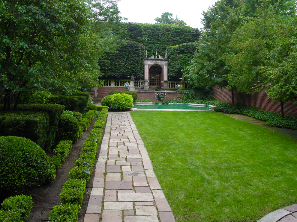 Traditional backyard garden in New York with a water feature.
