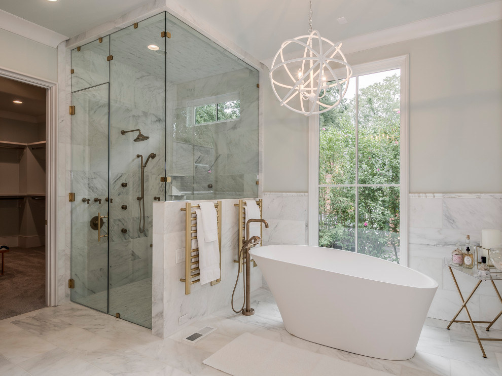 Klassisk inredning av ett badrum, med ett fristående badkar, en hörndusch, vit kakel, grå väggar, vitt golv och dusch med gångjärnsdörr