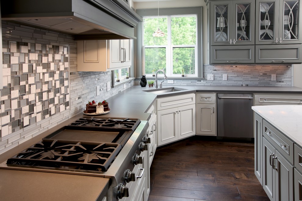 This is an example of a large transitional l-shaped eat-in kitchen in Grand Rapids with an undermount sink, concrete benchtops, grey splashback, glass tile splashback, stainless steel appliances, medium hardwood floors and with island.