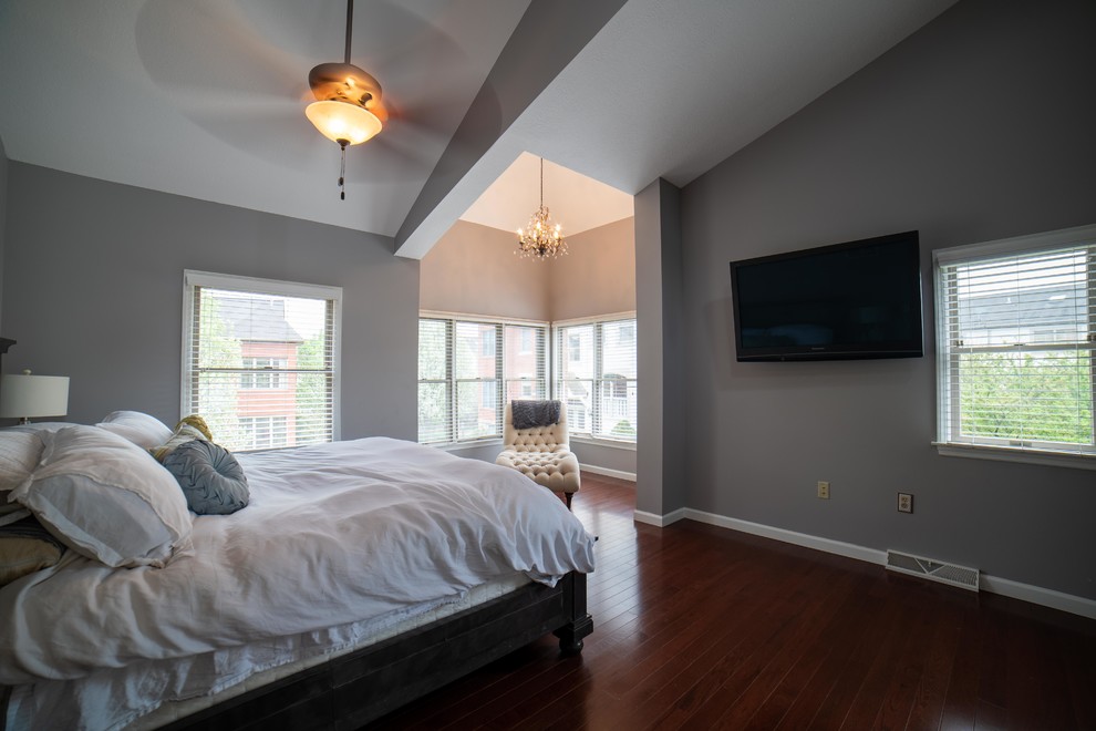 Photo of a mid-sized master bedroom in Other with grey walls, dark hardwood floors, no fireplace and red floor.