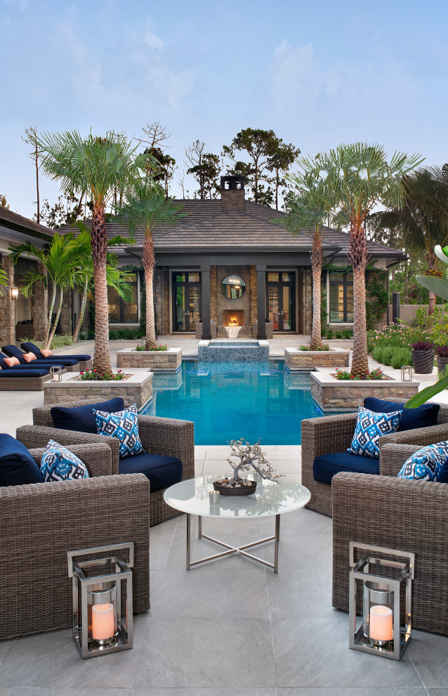 Imagen de piscina tropical a medida en patio con paisajismo de piscina y adoquines de piedra natural