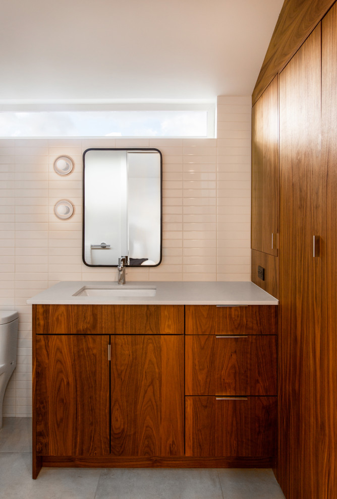 Стильный дизайн: маленькая ванная комната в стиле ретро с плоскими фасадами, темными деревянными фасадами, полновстраиваемой ванной, душем над ванной, унитазом-моноблоком, зеленой плиткой, керамогранитной плиткой, белыми стенами, полом из керамогранита, душевой кабиной, врезной раковиной, столешницей из искусственного кварца, серым полом, шторкой для ванной, белой столешницей, нишей, тумбой под одну раковину, встроенной тумбой и сводчатым потолком для на участке и в саду - последний тренд