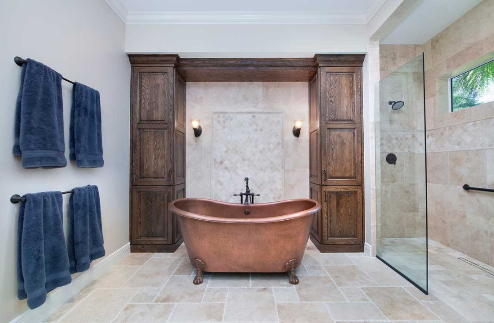 Large transitional master bathroom in Miami with raised-panel cabinets, a claw-foot tub, a curbless shower, a one-piece toilet, beige tile, porcelain tile, blue walls, travertine floors, an undermount sink, beige floor, an open shower and an enclosed toilet.