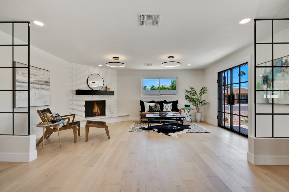 Example of a mid-sized 1960s open concept light wood floor and white floor living room design in Phoenix with white walls, a corner fireplace and a brick fireplace