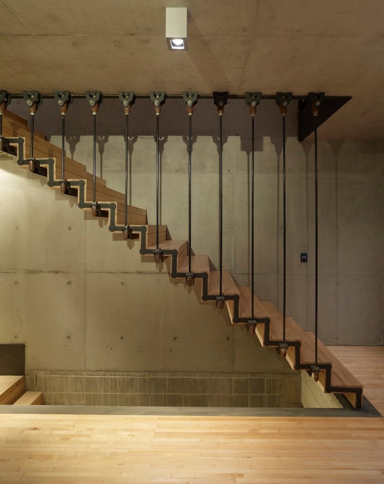 Photo of an industrial wood straight staircase in Sydney with concrete risers and metal railing.