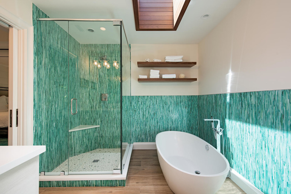Design ideas for a tropical master bathroom in Miami with a freestanding tub, a corner shower, blue tile, green tile, matchstick tile, beige walls, brown floor and a hinged shower door.