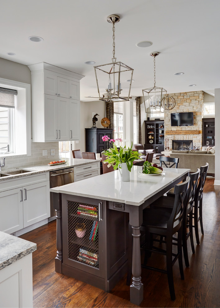 Inspiration for a large transitional u-shaped medium tone wood floor open concept kitchen remodel in Chicago with a double-bowl sink, flat-panel cabinets, white cabinets, quartz countertops, beige backsplash, subway tile backsplash, stainless steel appliances and an island