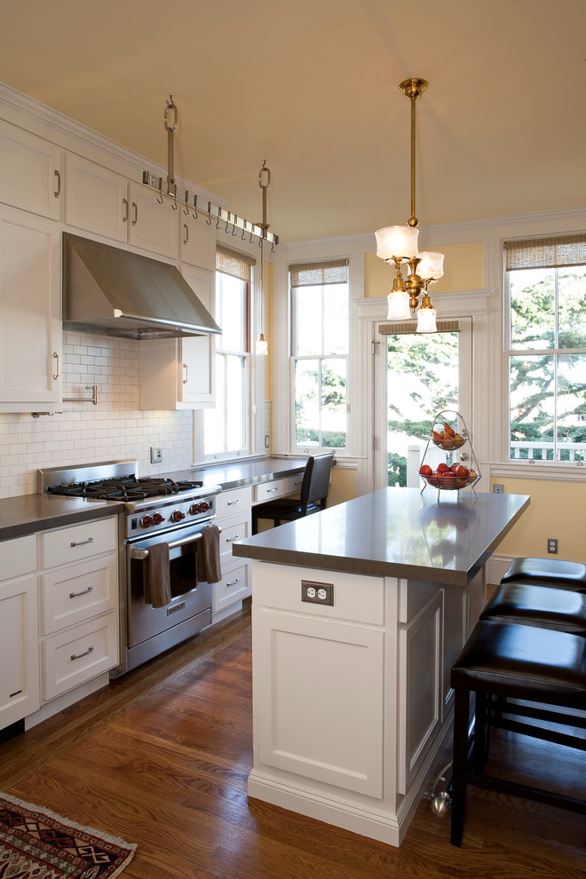Inspiration for a mid-sized traditional u-shaped eat-in kitchen in San Francisco with shaker cabinets, white cabinets, white splashback, stainless steel appliances, a single-bowl sink, porcelain splashback and with island.