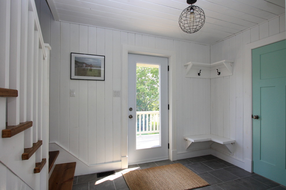 Photo of a beach style foyer in Montreal with white walls, a single front door and a glass front door.