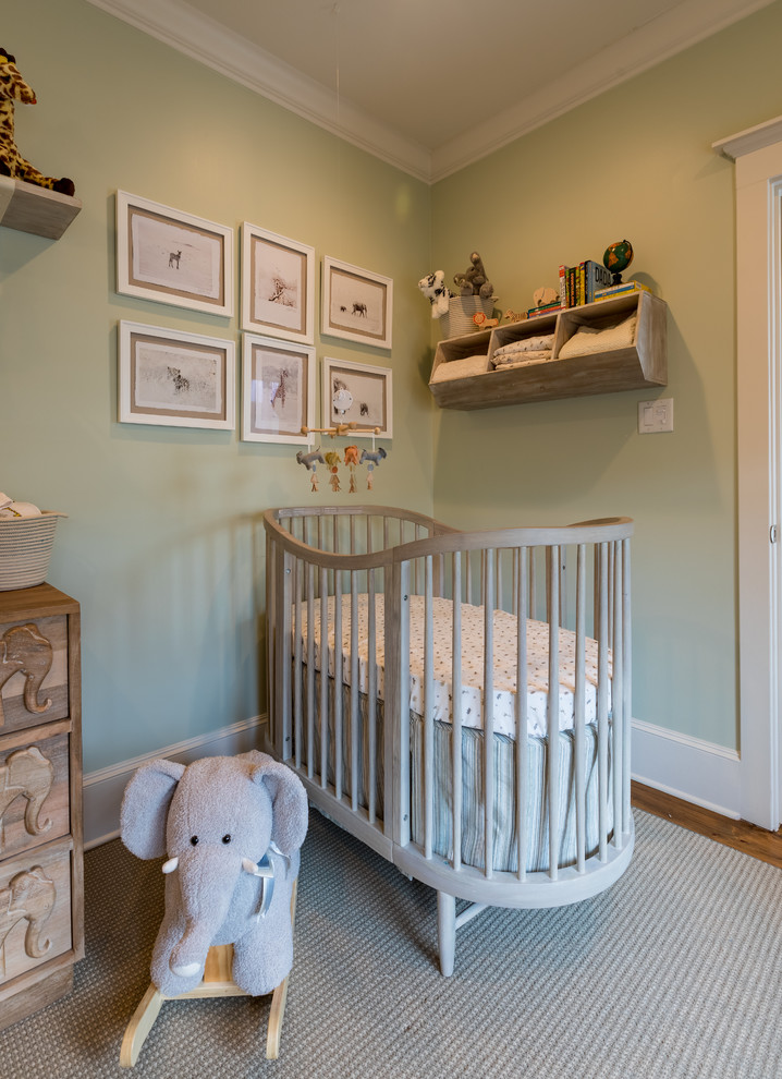 Photo of a small gender-neutral nursery in Houston with green walls, light hardwood floors and brown floor.