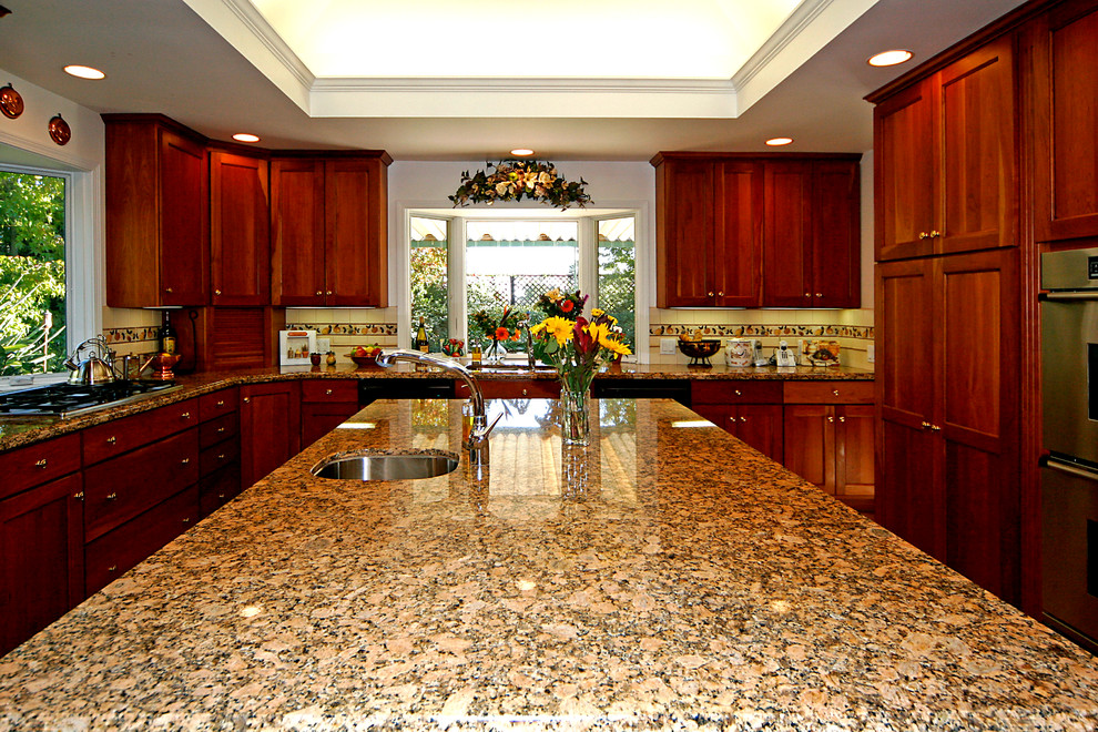 Inspiration for a large timeless u-shaped ceramic tile open concept kitchen remodel in Santa Barbara with an undermount sink, flat-panel cabinets, medium tone wood cabinets, granite countertops, white backsplash, ceramic backsplash, stainless steel appliances and an island